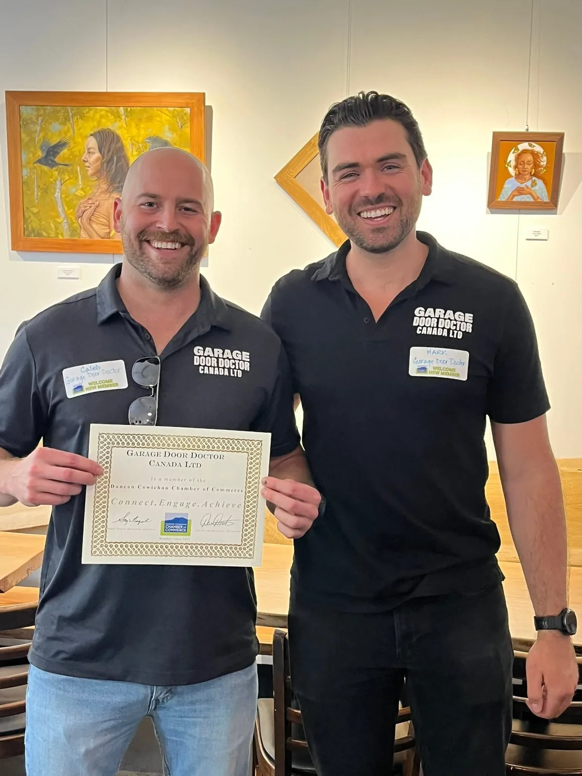 Garage Door Doctor Canada co-owners Caleb Paisley and Mark Sayers holding their Duncan Cowichan Chamber of Commerce membership certificate