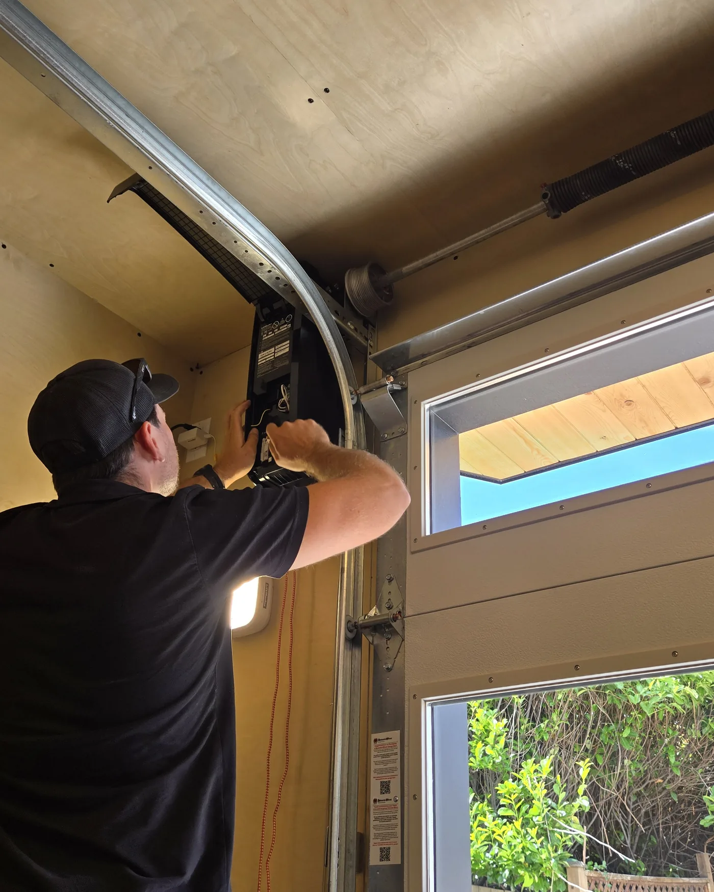 Mark, co-owner of Garage Door Doctor Canada, installing a wall-mount garage door opener in a Vancouver Island garage