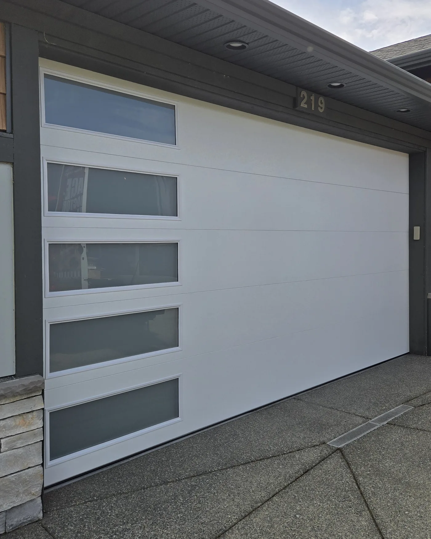 White 16x8 garage door with a vertical stack of frosted glass lites, installed by Garage Door Doctor Canada on a Vancouver Island home